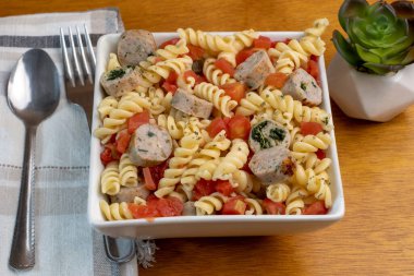Tavuk ıspanaklı ve doğranmış domatesli rotini makarna..