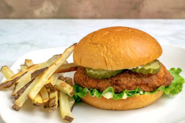 Ev yapımı patates kızartmasıyla servis edilen turşulu tavuk göğsü.