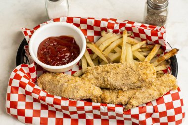 Ev yapımı patates kızartmasıyla servis edilen tavuklar.