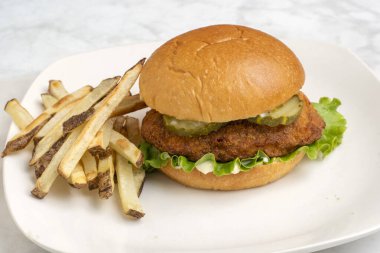 Ev yapımı patates kızartmasıyla servis edilen turşulu tavuk göğsü.