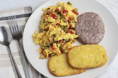 Biberli omlet ve sosisli börek ve kızarmış patates ile servis edilen soğan.