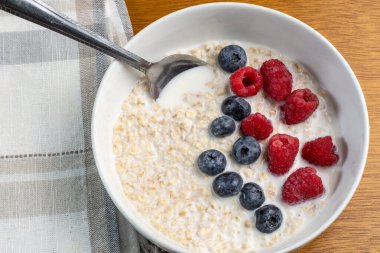 Taze böğürtlen ve ahududu ile servis edilen yulaf ezmesi