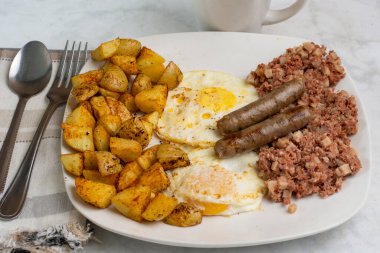 Kahvaltıda az pişmiş yumurta, mısır gevreği ve patates kızartması.