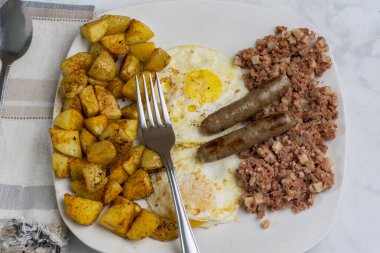 Kahvaltıda az pişmiş yumurta, mısır gevreği ve patates kızartması.