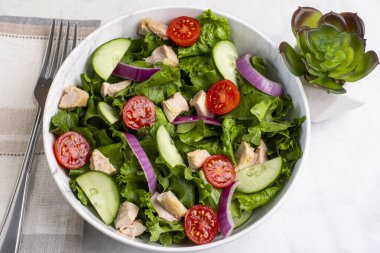  Domatesli salata, marul ve tavukla servis edilen salatalık.