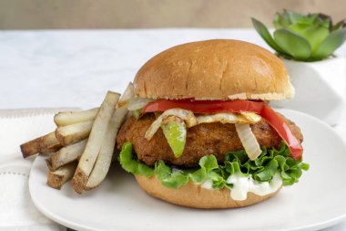 Baharatlı tavuk göğsü soğan ve biberli ve kızarmış patatesli çörek.