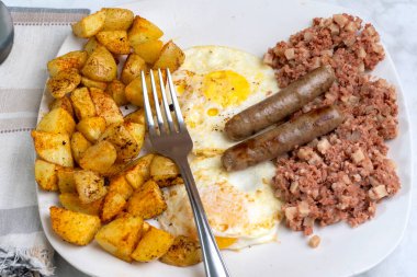 Kahvaltıda az pişmiş yumurta, mısır gevreği ve patates kızartması.