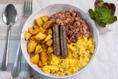  Ev kızartması, sosis ve mısır gevreğiyle çırpılmış yumurta.