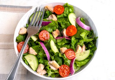  Domatesli salata, marul ve tavukla servis edilen salatalık.