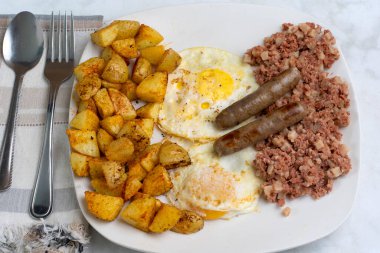 Kahvaltıda az pişmiş yumurta, mısır gevreği ve patates kızartması.