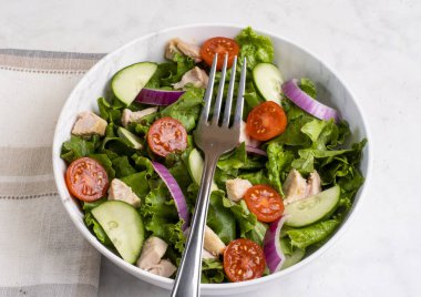  Domatesli salata, marul ve tavukla servis edilen salatalık.
