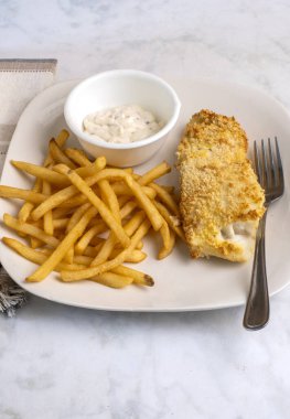 Kızarmış patates ve tarter soslu fırında mezgit.