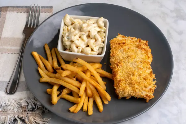 Fırında balık, patates kızartması ve makarna salatası.