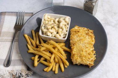 Fırında balık, patates kızartması ve makarna salatası.