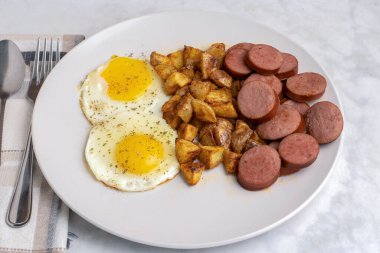 Kızarmış yumurta, yanında sebze, yanında sosis ve patates kızartması.