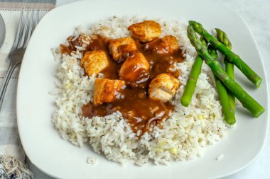 Sarımsaklı beyaz pirinç ve tavuk ısırığı soslu soğan.