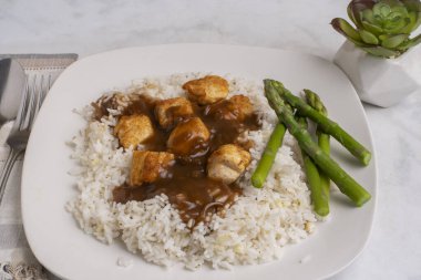 Sarımsaklı beyaz pirinç ve tavuk ısırığı soslu soğan.