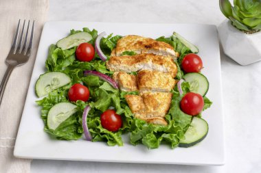  Dilimlenmiş tavuk göğsüyle servis edilen salata.