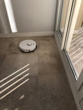 Robotik süpürge dairede fayanslı zeminde çalışıyor.