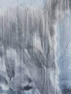 Gri duvar, toprak, kir ve diğer dokulardan oluşan soyut bir arkaplan oluşturuyor.