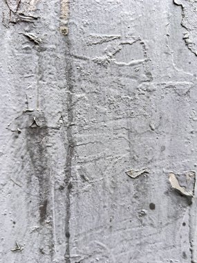 Yıpranmış beton duvar, soyulmuş boya ve çizikler soyut desenli arka plan oluşturuyor.