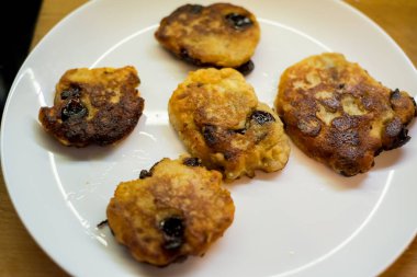 Beyaz tabakta servis edilen kirazlı süzme peynirli krepler. Altın hamuru, canlı böğürtlenlerin zıttıdır. Sunum lezzetli ve taze görünümün altını çiziyor. Ağız sulandırıcı görüntü tatmaya davet eder.