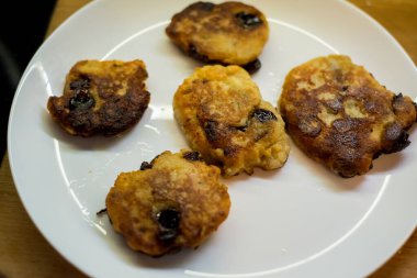 Beyaz tabakta servis edilen kirazlı süzme peynirli krepler. Altın hamuru, canlı böğürtlenlerin zıttıdır. Sunum lezzetli ve taze görünümün altını çiziyor. Ağız sulandırıcı görüntü tatmaya davet eder.