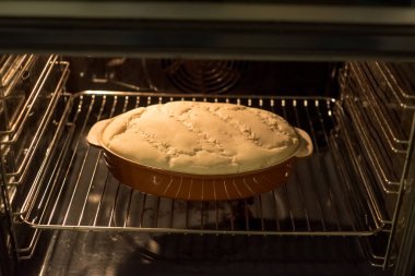 Seramik haldeki gübre artıyor. Teşekkürler maya. Fırının içinde parlak ışık pişmeye hazır olduğunu gösteriyor. Kıtır yüzey görünür; yumuşak ısı dönüşümü ilerletir, mayalanma başlangıcını işaret eder. Taze dalgalanmalar.