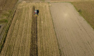 Çiftlik arazisi, çiftçiler tarım arazisinde traktörle çalışıyorlar.,