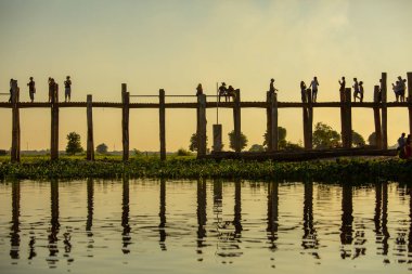 Mandalay, Myanmar, 16 Kasım 2016: Tanımlanamayan kişiler U Bein Köprüsü 'nden geçiyor. Burma 'da en çok ziyaret edilen yerlerden biri.