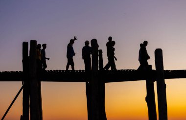 Amarapura, Myanmar - 22 Kasım 2016: Myanmar 'da gün batımında kimliği belirsiz kişiler U Bein köprüsünde yürüyor. U Bein köprüsü dünyanın en uzun meşe köprüsü..