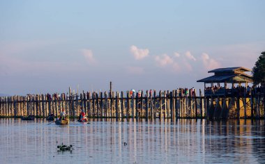 Amarapura, Myanmar - 22 Kasım 2016: Myanmar 'da gün batımında kimliği belirsiz kişiler U Bein köprüsünde yürüyor. U Bein köprüsü dünyanın en uzun meşe köprüsü..