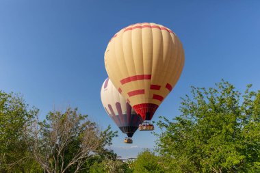 Denizli, Türkiye, 1 Mayıs 2023: Pamukkale 'de güneş doğarken sıcak hava balonları ve doğal travertin havuzları, 