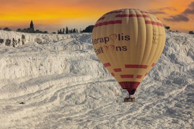 Denizli, Türkiye, 1 Mayıs 2023: Pamukkale 'de güneş doğarken sıcak hava balonları ve doğal travertin havuzları, 