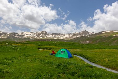 Berelan yaylası, karlı dağ manzarası ve çiçek açan zemin ve kamp çadırı, Hakkari, Türkiye