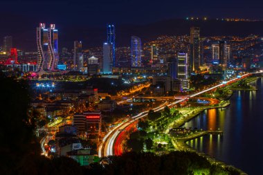 Akşamları Bayrakli 'nin yüksek tepesinden İzmir Körfezi manzarası. Uzun pozlama, düşük ışık.