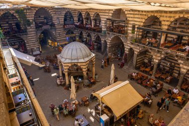 DIYARBAKIR, TURKEY, 05 ECTOBER 2023: İnsanların kahvaltı yaptığı ortaçağ tarihi binası ve Diyarbakır 'ın merkezi olan küçük dükkanlar,