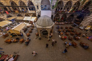 DIYARBAKIR, TURKEY, 05 ECTOBER 2023: İnsanların kahvaltı yaptığı ortaçağ tarihi binası ve Diyarbakır 'ın merkezi olan küçük dükkanlar,