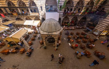 DIYARBAKIR, TURKEY, 05 ECTOBER 2023: İnsanların kahvaltı yaptığı ortaçağ tarihi binası ve Diyarbakır 'ın merkezi olan küçük dükkanlar,