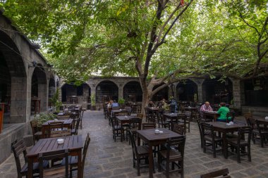 Diyarbakır, Türkiye, 5 Ekim 2023: Diyarbakır 'da bugün kafeler ve küçük dükkanlar için kullanılan bir ortaçağ hanı olan Suluklu Han' ın avlusunda kimliği belirsiz kişiler oturuyor