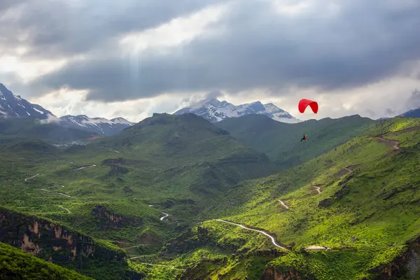 snowy mountains and action sports with red paramotor, Cukurca, Hakkari