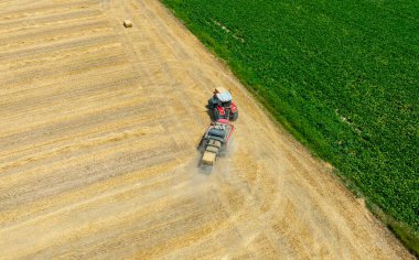Çiftlik arazisi, çiftçiler tarım arazisinde traktörle çalışıyorlar.,