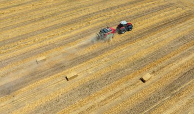 Çiftlik arazisi, çiftçiler tarım arazisinde traktörle çalışıyorlar.,