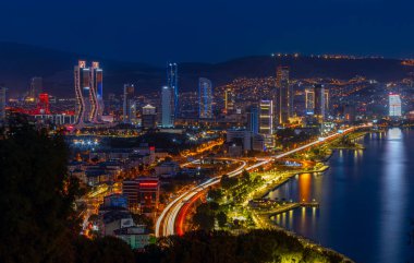 Akşamları Bayrakli 'nin yüksek tepesinden İzmir Körfezi manzarası. Uzun pozlama, düşük ışık.