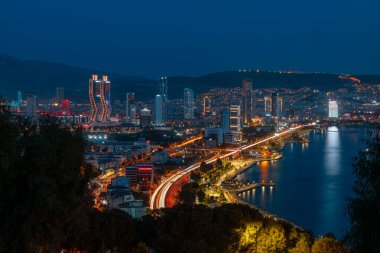 Akşamları Bayrakli 'nin yüksek tepesinden İzmir Körfezi manzarası. Uzun pozlama, düşük ışık.