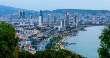 Akşamları Bayrakli 'nin yüksek tepesinden İzmir Körfezi manzarası. Uzun pozlama, düşük ışık.