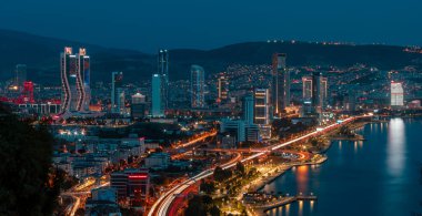 Akşamları Bayrakli 'nin yüksek tepesinden İzmir Körfezi manzarası. Uzun pozlama, düşük ışık.