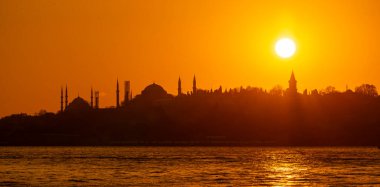 İstanbul 'daki tarihi yarımadanın panoramik günbatımı, Sultanahmet Camii' nin siluetleri, Ayasofya Camii, arka planda Topkapı Sarayı, Türkiye