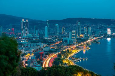 Akşamları Bayrakli 'nin yüksek tepesinden İzmir Körfezi manzarası. Uzun pozlama, düşük ışık.
