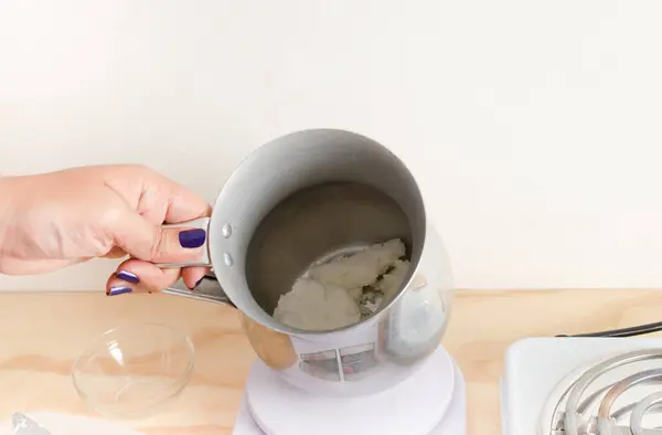 stock image Woman weighing soy vegetable wax for biodegradable candles, vegetable waxes, organic. Small businesses, female businesses.